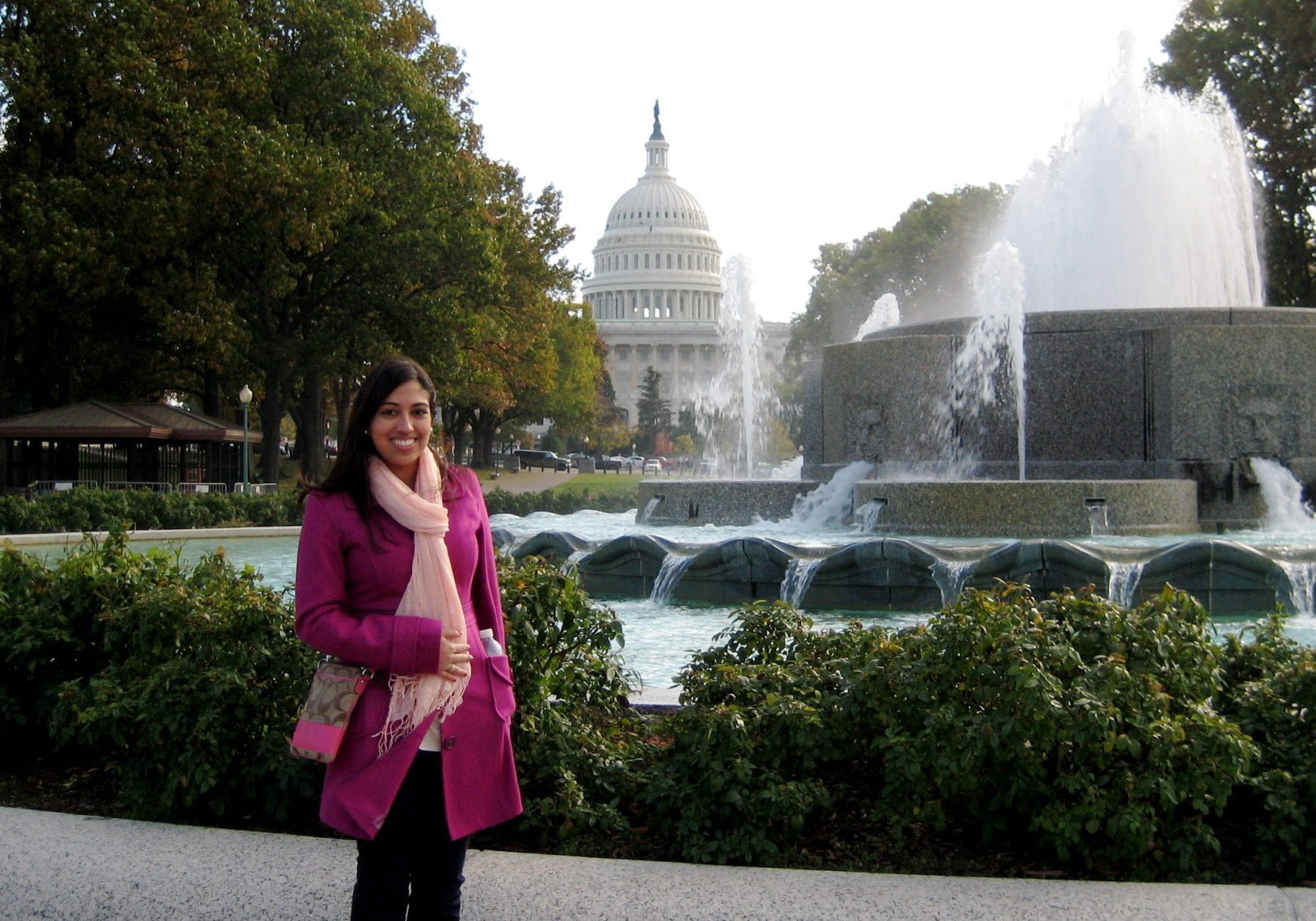 Photo of smiling person in front of a water fountain. US Capitol building in the background. 